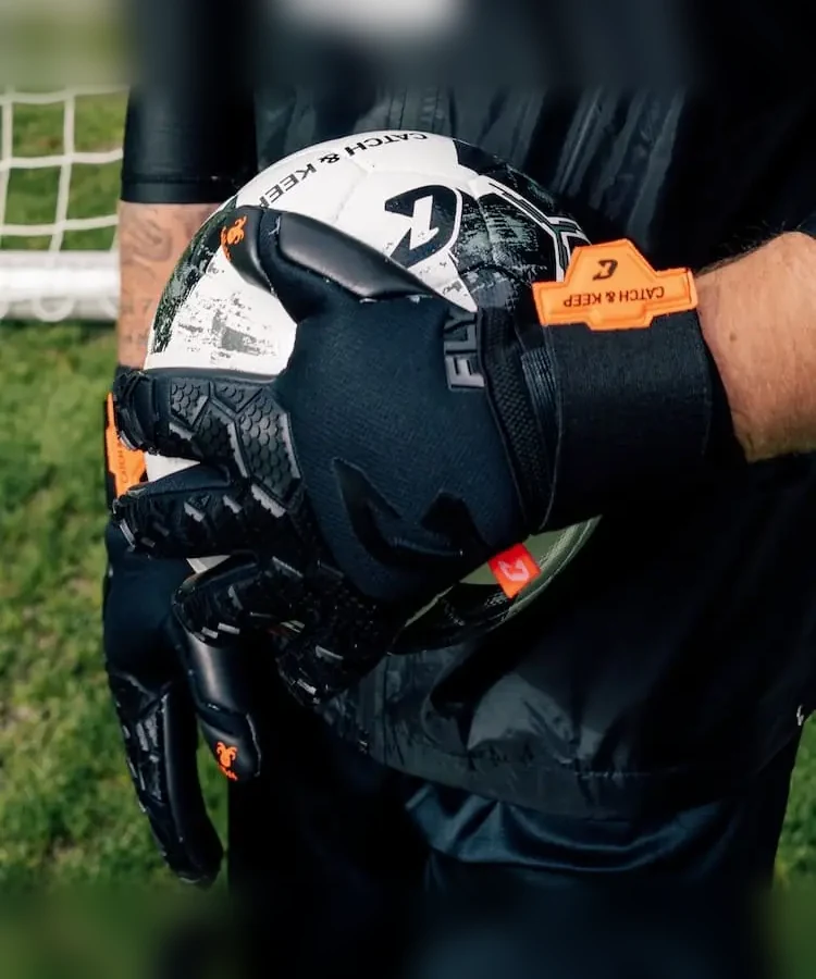 Schwarzer Fly Soul Torwarthandschuh hält einen Ball – Nahaufnahme